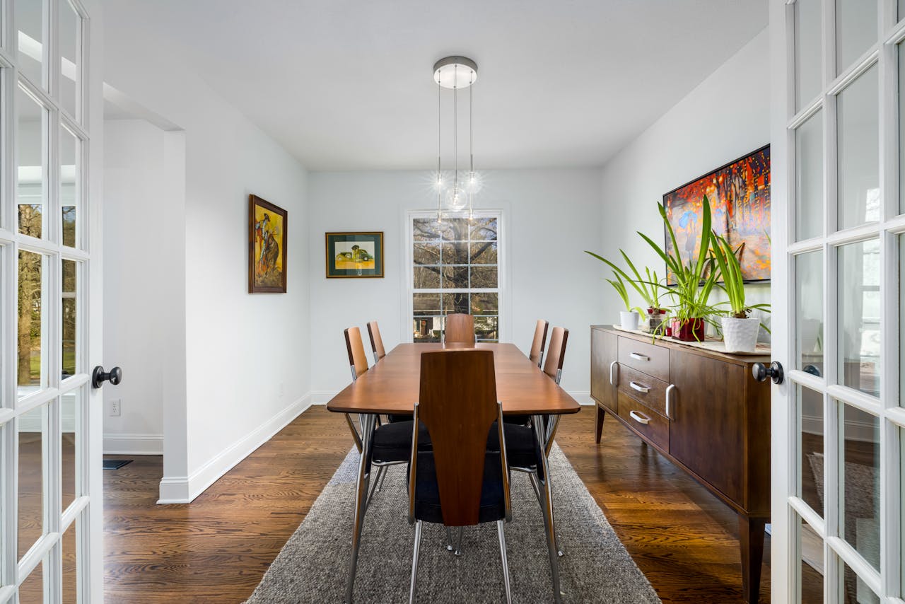 Bright modern dining room with wooden table and contemporary decor.